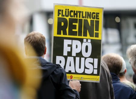 Protesters hold a poster against Austrian Freedom Party (FPO) during a demonstration in support of refugees in Vienna, Austria, October 3, 2015. REUTERS/Heinz-Peter Bader