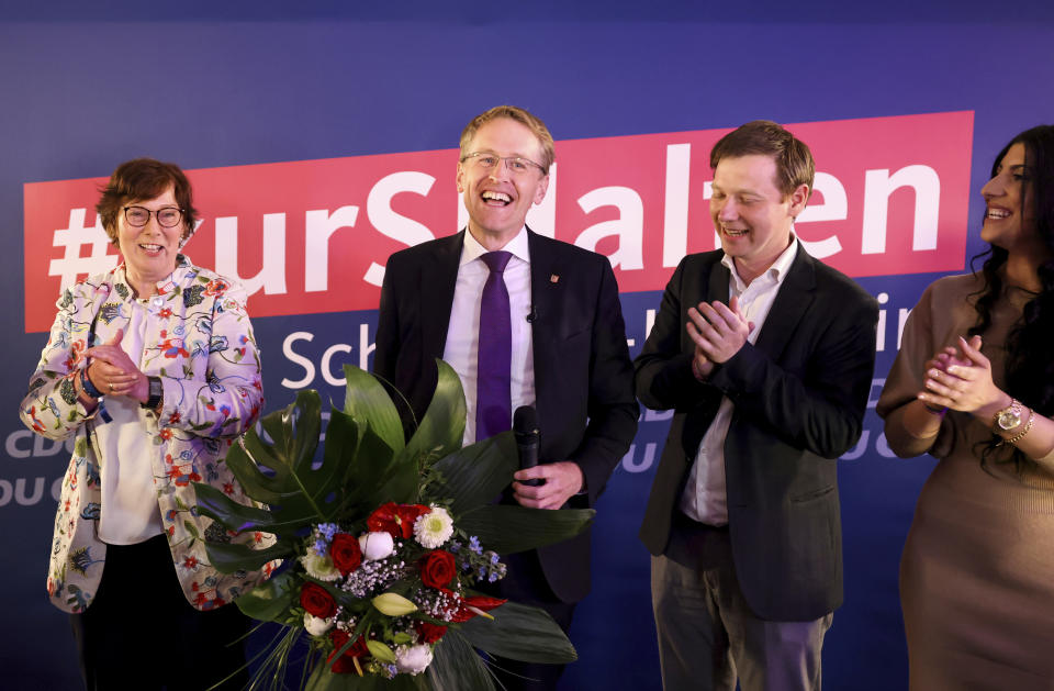 Daniel G'nther (CDU) Minister President of Schleswig-Holstein and top candidate for his party, second left, stands on stage at the election party after the first forecasts for the state election in Schleswig-Holstein were announced, In Kiel, Germany, Sunday, May 8, 2022. (Christian Charisius/dpa via AP)