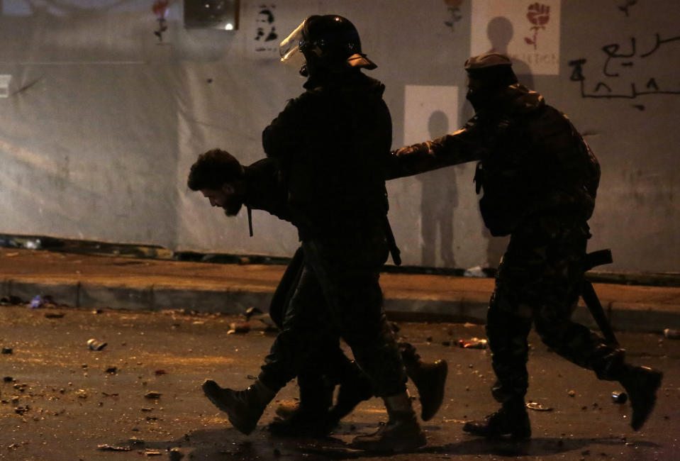 Policías libaneses detienen a un manifestante contrario al gobierno tras dispersar una protesta en Beirut, Líbano, el sábado 18 de enero de 2020. (AP Foto/Hassan Ammar)