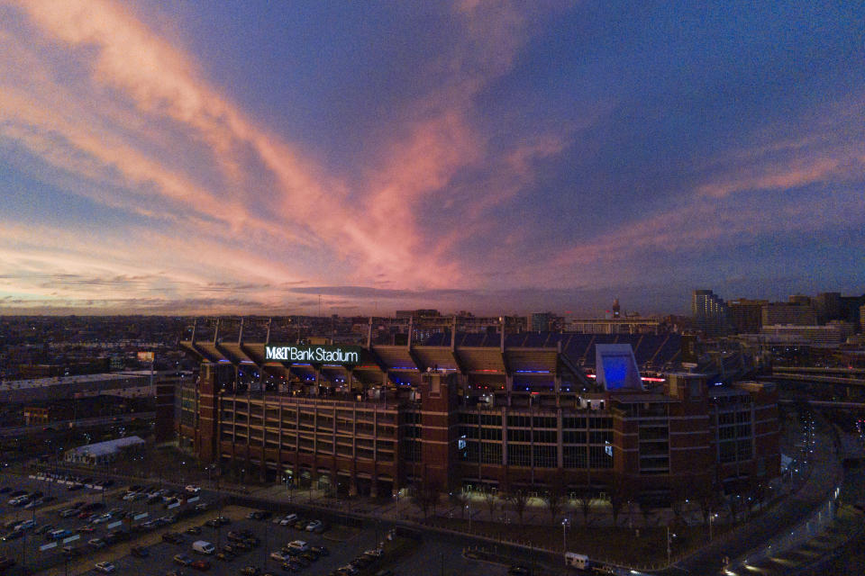 Clouds are lit up with the sunset light over M&T Bank, the home stadium of the Baltimore Ravens, donning lights in the colors of the Buffalo Bills in support of safety Damar Hamlin, Wednesday, Jan. 4, 2023, in Baltimore. Hamlin was taken to the hospital after collapsing on the field during an NFL football game against the Cincinnati Bengals on Monday night. (AP Photo/Julio Cortez)