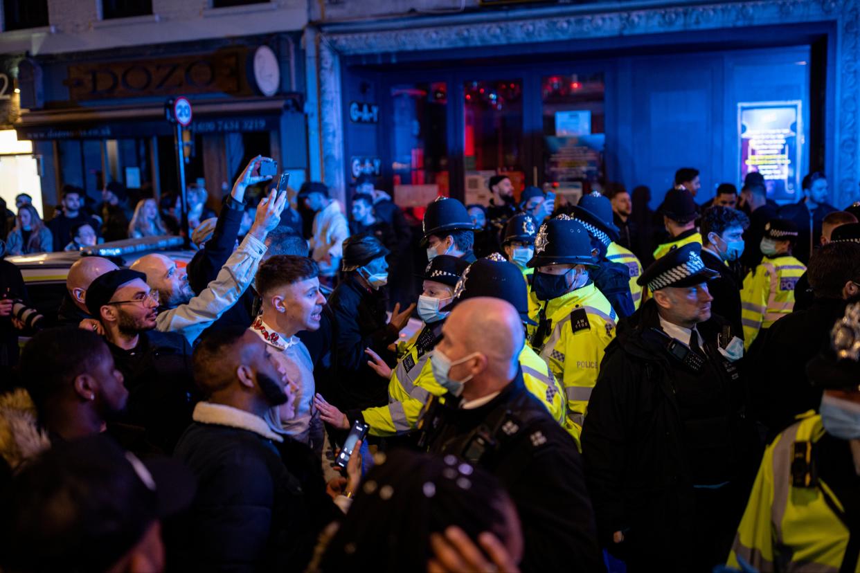 <p>Police officers attempt to keep the crowd away from a police van after a man was arrester on Old Compton Street in Soho</p> (Getty Images)
