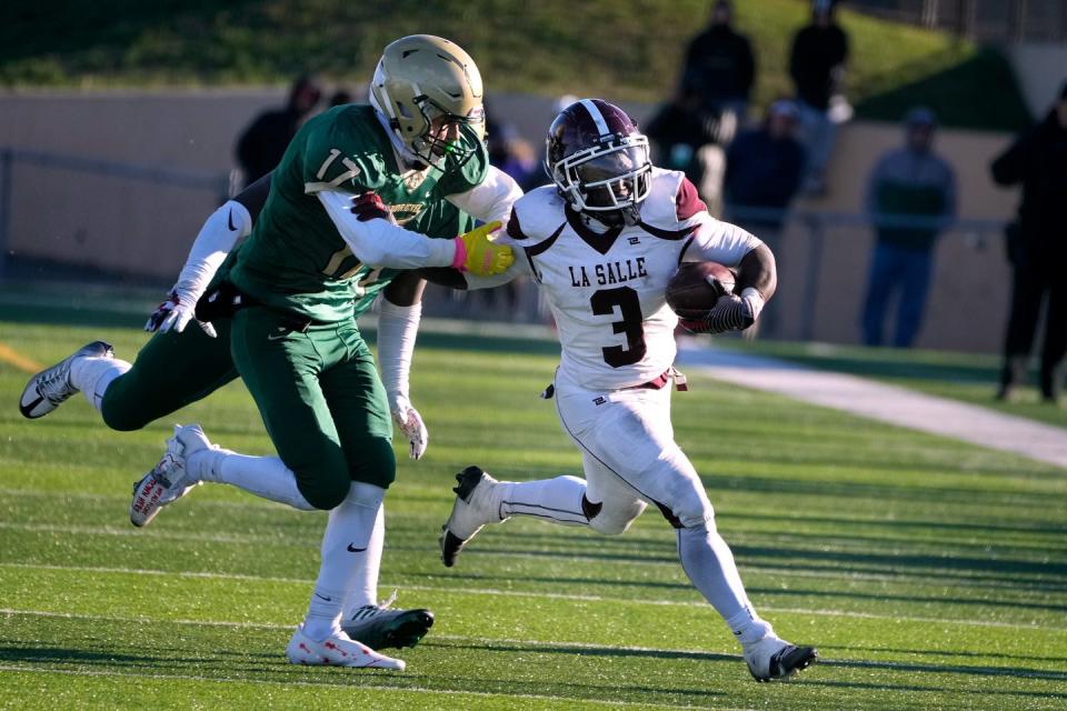 Hendricken defender Noah West runs down La Salle running back Jamezell Lassiter in the second half. 