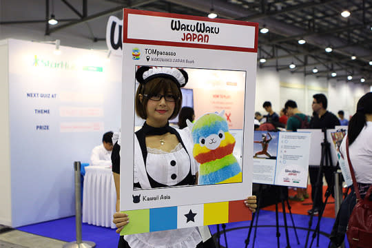 A staff memeber posing with the Waku Waku Japan Instagram cut-out board. (Photo: Sharlene Sankaran/Yahoo Singapore)