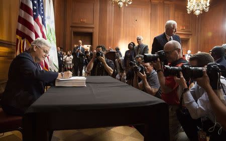 Environmental Protection Agency (EPA) Administrator Gina McCarthy signs a proposal under the Clean Air Act to cut carbon pollution from existing power plants during a news conference in Washington June 2, 2014. REUTERS/Joshua Roberts