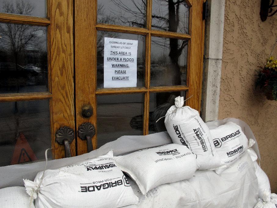 Sandbags line the doors of the Alamo truck stop and casino along U.S. Interstate 80 due to flooding Sunday, Jan. 8, 2017 in Sparks, Nev. More than 1,000 homes have been evacuated due to overflowing streams and drainage ditches in the area, which remains under a flood warning through Tuesday. (AP Photo/Scott Sonner)