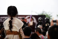 A child dressed as Rey from Star Wars: The Force Awakens watches as members of the Star Wars parade take the stage. (Photo: Bryan Huang/Yahoo Singapore)