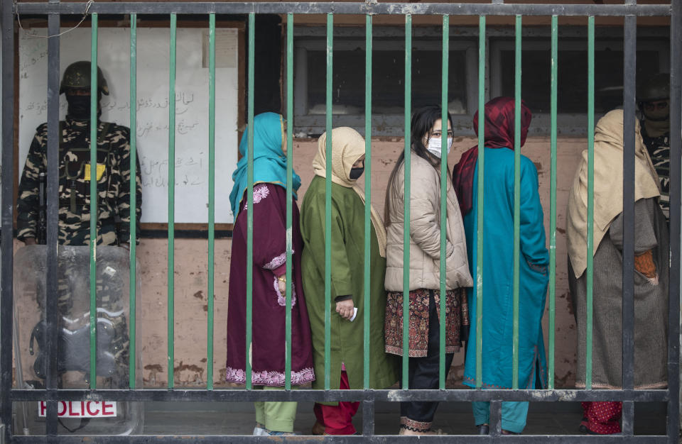 Kashmiris stand in a queue to cast their votes during the first phase of District Development Councils election on the outskirts of Srinagar, Indian controlled Kashmir, Saturday, Nov. 28, 2020. Thousands of people in Indian-controlled Kashmir voted Saturday amid tight security and freezing cold temperatures in the first phase of local elections, the first since New Delhi revoked the disputed region's semiautonomous status. (AP Photo/Mukhtar Khan)