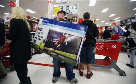 A holiday shopper carries a discounted television to the checkout at the Target retail store in Chicago, Illinois, in this file photo taken November 28, 2013. REUTERS/Jeff Haynes/Files