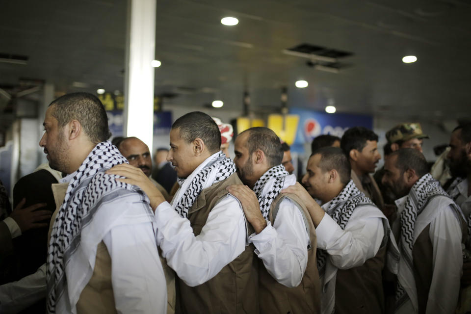 Yemeni prisoners gather during their arrival after being released by the Saudi-led coalition in the airport of Sanaa, Yemen, Thursday, Nov. 28, 2019. The International Committee of the Red Cross says over a hundred rebel prisoners released by the Saudi-led coalition have returned to Houthi-controlled territory in Yemen, a step toward a long-anticipated prisoner swap between the warring parties. (AP Photo/Hani Mohammed)