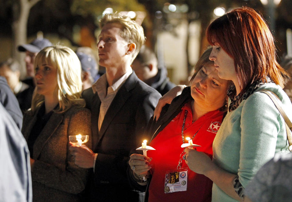 People gather in Centennial Plaza in Midland, Texas on Saturday, Nov. 17, 2012 for a candlelight vigil held in honor of four veterans who were killed when a freight train hit a parade float Thursday. (AP Photo/Midland Reporter-Telegram, James Durbin)