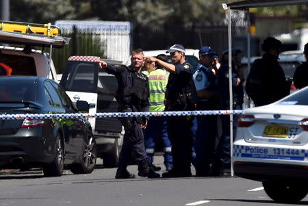 Police and emergency services personnel are behind a road block at the scene of a shooting in the western Sydney suburb of Ingleburn, March 7, 2016. REUTERS/Dan Himbrechts/AAP