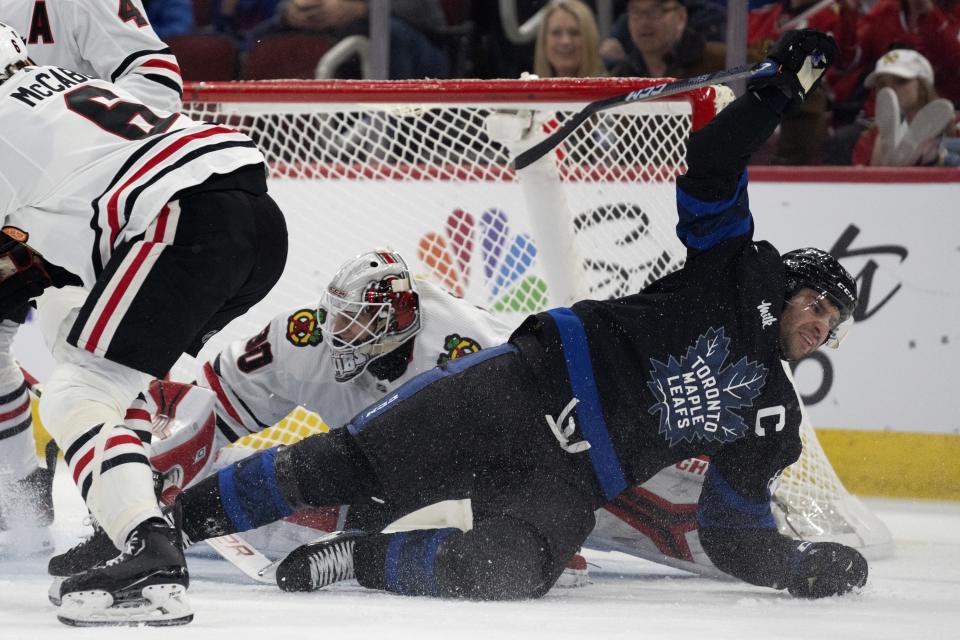 Toronto Maple Leafs center John Tavares, right, takes a dive in front of Chicago Blackhawks goaltender Jaxson Stauber during the first period of an NHL hockey game Sunday, Feb. 19, 2023, in Chicago. (AP Photo/Erin Hooley)