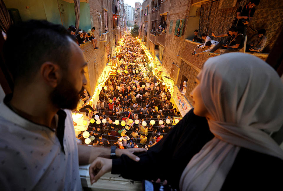 Residents of Ezbet Hamada in Cairo's Mataria district gather to eat Iftar, the meal to end their fast at sunset, during the holy fasting month of Ramadan, on April 6, 2023.