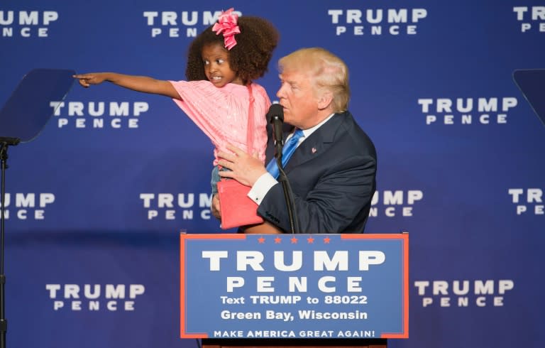 Republican presidential nominee Donald Trump holds a child as he speaks during a rally at the KI Convention Center on October 17, 2016 in Green Bay, Wisconsin