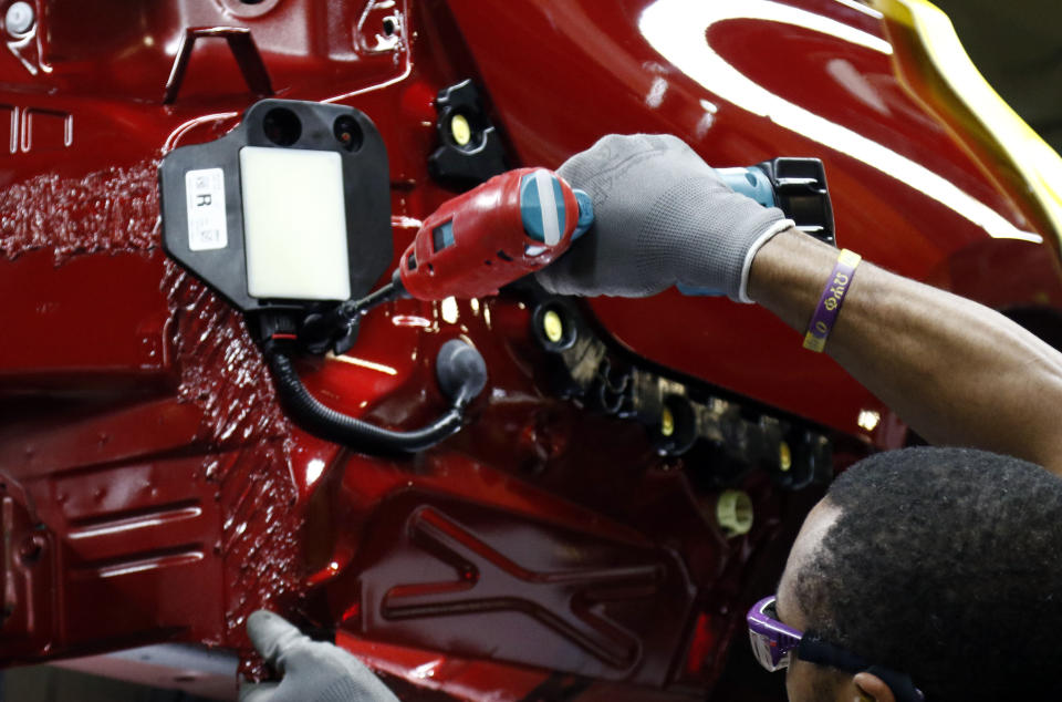 FILE- In this Sept. 27, 2018, file photo a line technician works on assembling a vehicle at Nissan Canton Vehicle Assembly Plant in Canton, Miss. Nissan Motor Co. announced Thursday, Jan. 17, 2019, that it’s cutting up to 700 contract workers at its Mississippi assembly plant, citing slowing sales for vans and Titan pickup trucks that it makes there. (AP Photo/Rogelio V. Solis, File)