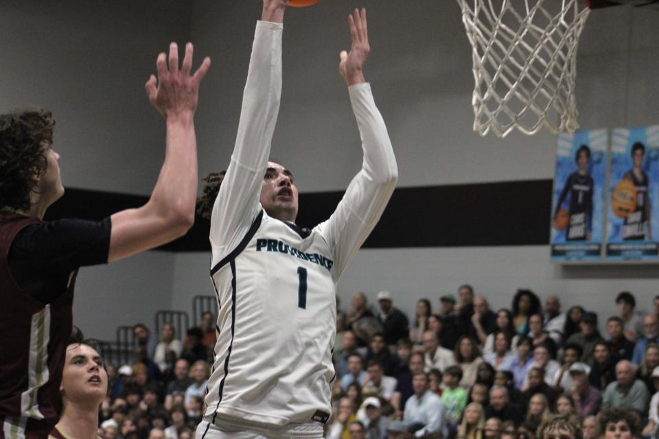 Providence guard Chris Arias (1) rises for a layup against Episcopal center Grady Schwartz (0) in District 3-3A basketball.