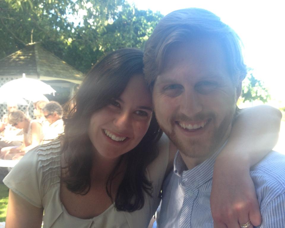 The author, left, and her husband. They are sitting outside and smiling at the camera.