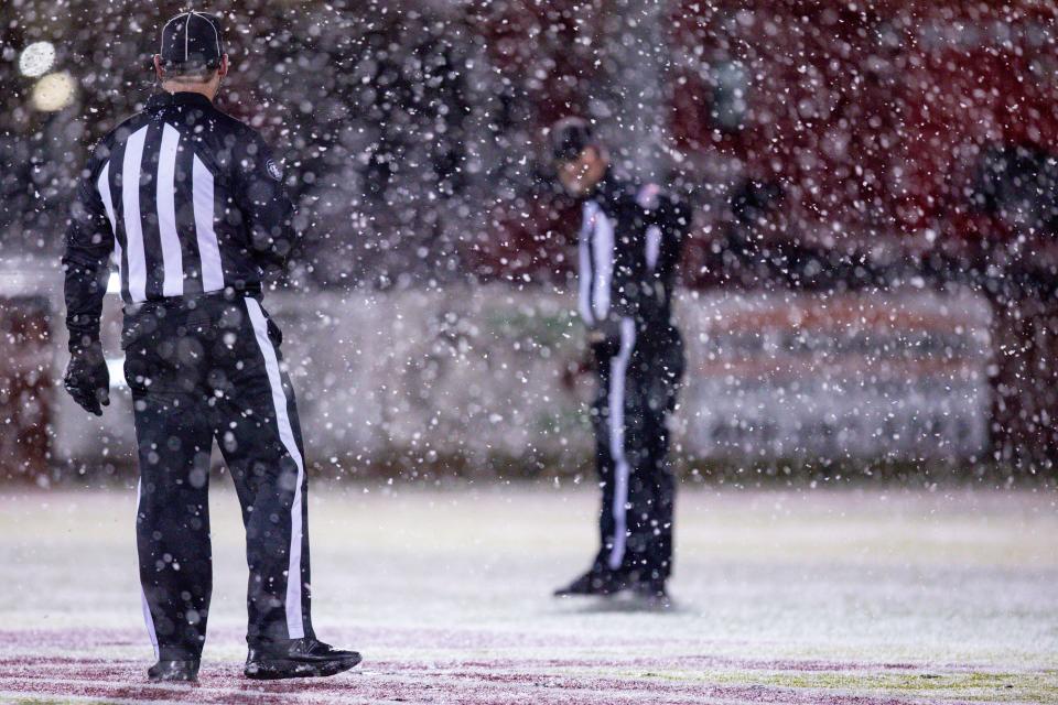 Referees stand on the field in the snow before a high school football game between Tuttle High School and Chickasha High School in Tuttle on Friday, Nov. 11, 2022.