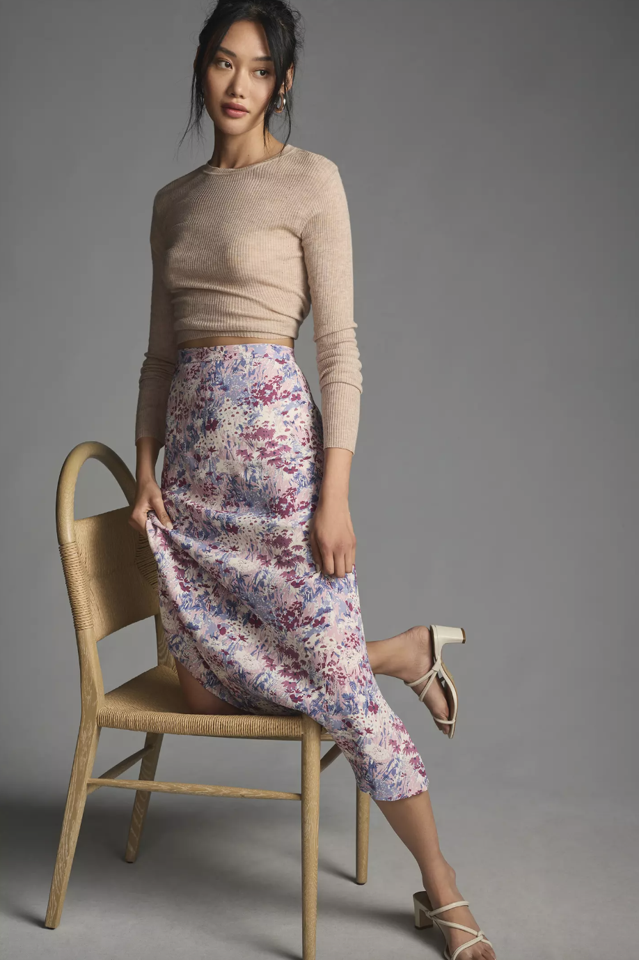 model wearing beige sweater and light purple floral Reformation Bea Skirt (photo via Anthropologie)