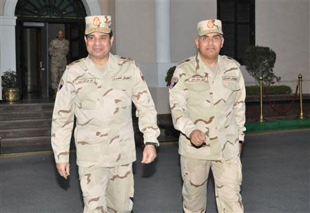 Egypt's army chief Field Marshal Abdel Fattah al-Sisi (L) walks with Gen. Sidqi Sobhi (R) after meeting with members of the Supreme Council of the Armed Forces, in Cairo March 26, 2014. REUTERS/Egyptian Ministry of Defence/Handout