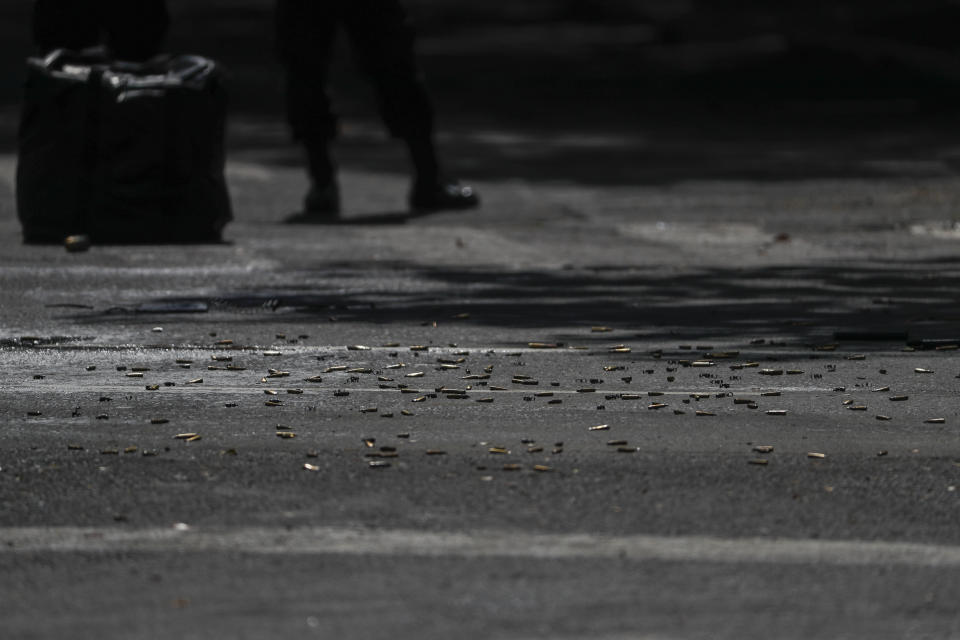 Cartridges carpet the pavement at the scene where the Mexican capital's police chief was attacked by gunmen in Mexico City, Friday, June 26, 2020. Heavily armed gunmen attacked and wounded Omar García Harfuch in an operation that left several dead. (AP Photo/Rebecca Blackwell)