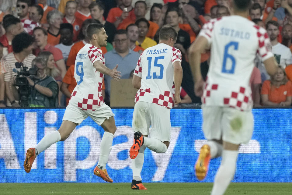 Croatia's Andrej Kramaric, left, celebrates after scoring his side's first goal from the penalty spot during the Nations League semifinal soccer match between the Netherlands and Croatia at De Kuip stadium in Rotterdam, Netherlands, Wednesday, June 14, 2023. (AP Photo/Peter Dejong)