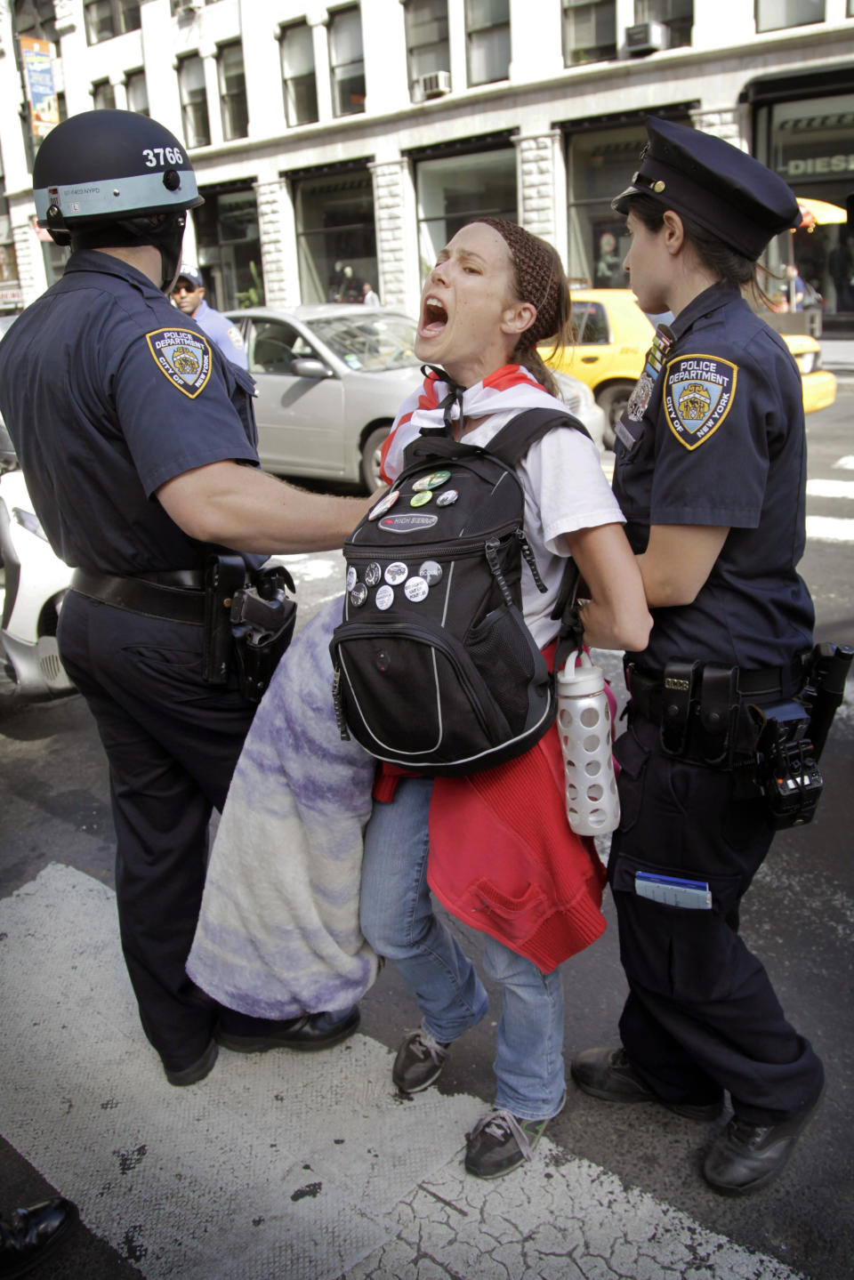 Police take Amanda Lodoza, an activist associated with the Occupy Wall Street movement, into custody during a march in New York, Sunday, Sept. 16, 2012. The Occupy Wall Street movement will mark its first anniversary on Monday. (AP Photo/Seth Wenig)