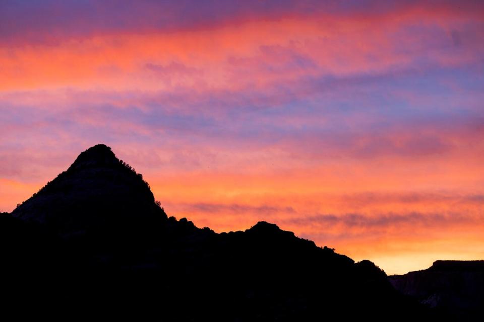 The setting suns casts a colorful palette in the skies above Zion Canyon at the end of the Canyon Overlook trail