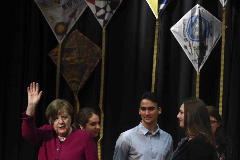 German Chancellor Angela Merkel waves as she stands by students during her visit in a German school in Athens, Friday, Jan. 11, 2019. Merkel is widely blamed in Greece for the austerity that the country has lived through for much of the past decade, which led to a sharp and prolonged recession and a consequent fall in living standards. (AP Photo/Petros Giannakouris)