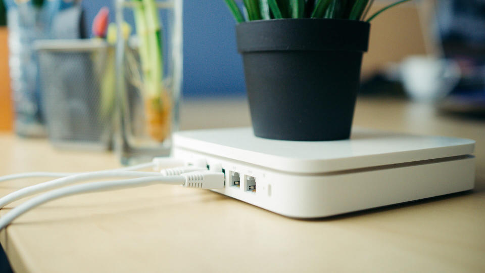 Closeup of a broadband router, plant in pot is placed on router, with a blur background.