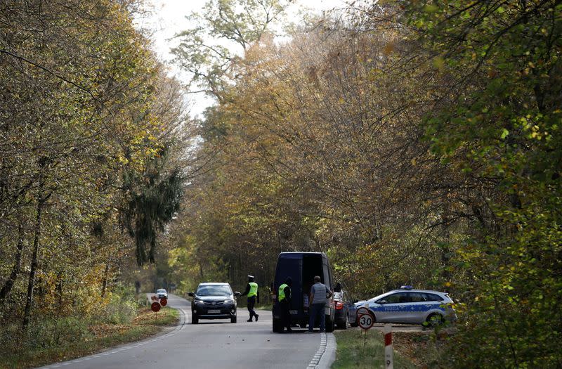 Polish police officers examine vehicles at a checkpoint on entry to the prohibited state of emergency zone, created to better manage an ongoing migrant crisis on the Belarusian-Polish border near Bialowieza