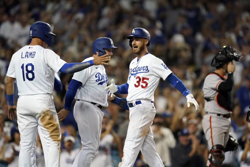 Los Angeles Dodgers' Cody Bellinger (35) celebrates his grand slam at home plate with Max Muncy.