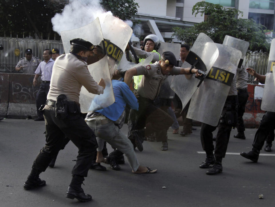 Indonesian police officers try to catch students during a protest against price hikes on fuel, in Jakarta, Indonesia, Wednesday, March 14, 2012. (AP Photo/Achmad Ibrahim)
