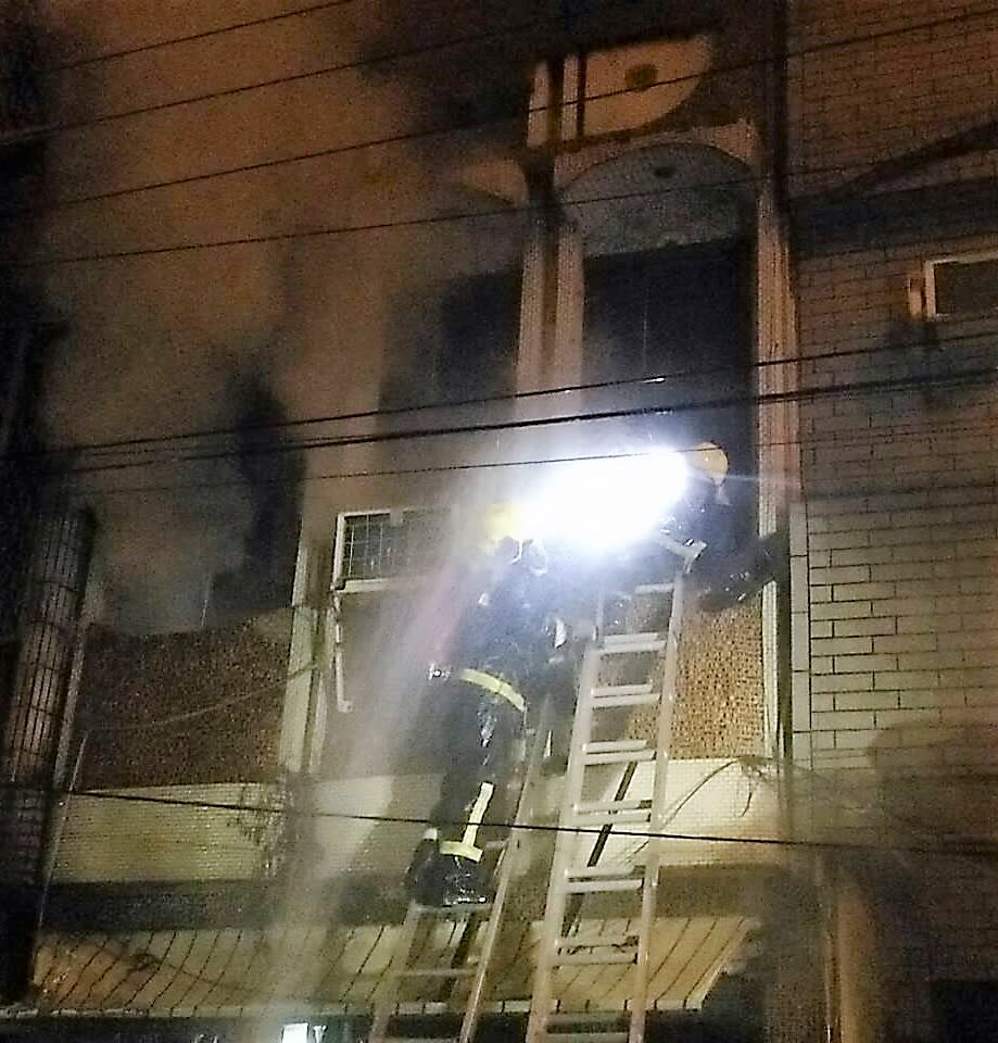 屏東新園鄉12日晚上9時許一處民宅發生火警，消防隊前往救火，41歲的新園消防分隊義消小隊長李俊宏不幸殉職。圖為消防人員進到火宅搶救情形。(中央社/屏東消防局提供)