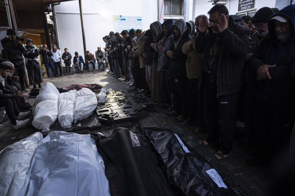 Palestinians mourn their relatives, killed in the Israeli bombardment of the Gaza Strip, outside a morgue in Rafah, southern Gaza, Tuesday, Feb. 6, 2024. (AP Photo/Fatima Shbair)