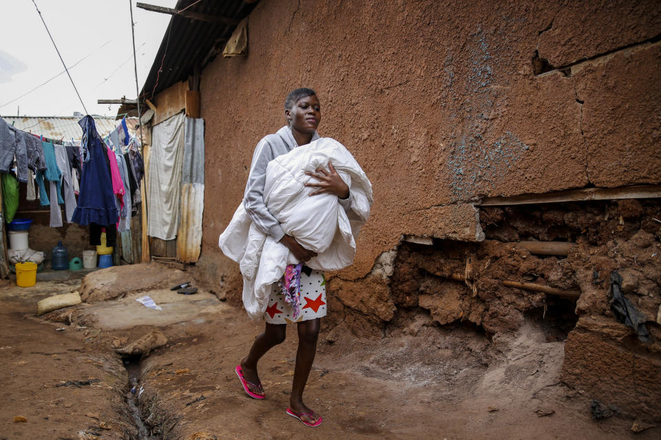 Veronica Atieno carries her daughter Shaniz Joy Juma, delivered a month earlier by a traditional birth attendant during a dusk-to-dawn curfew, in the Kibera slum of Nairobi, Kenya, Friday, July 3, 2020. Kenya already had one of the worst maternal mortality rates in the world, and though data are not yet available on the effects of the curfew aimed at curbing the spread of the coronavirus, experts believe the number of women and babies who die in childbirth has increased significantly since it was imposed mid-March. (AP Photo/Brian Inganga)