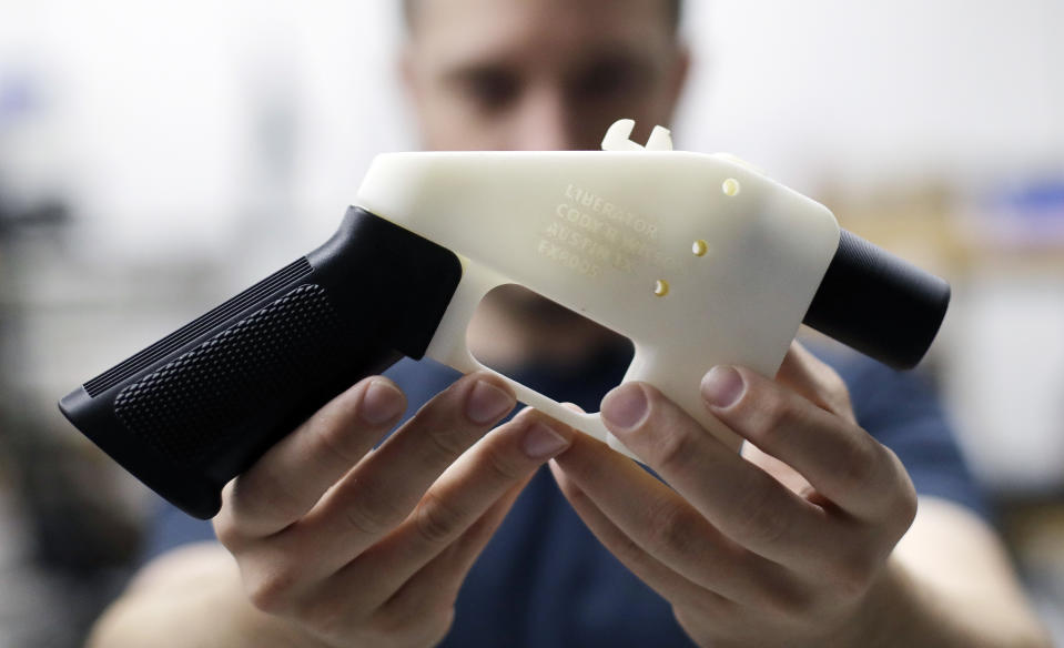 FILE - In this Aug. 1, 2018, file photo, Cody Wilson, with Defense Distributed, holds a 3D-printed gun called the Liberator at his shop in Austin, Texas. A federal judge in Seattle is scheduled to hear arguments Tuesday, Aug. 21, 2018, on whether to block a settlement the U.S. State Department reached with a company that wants to post blueprints for printing 3D weapons on the internet. (AP Photo/Eric Gay)