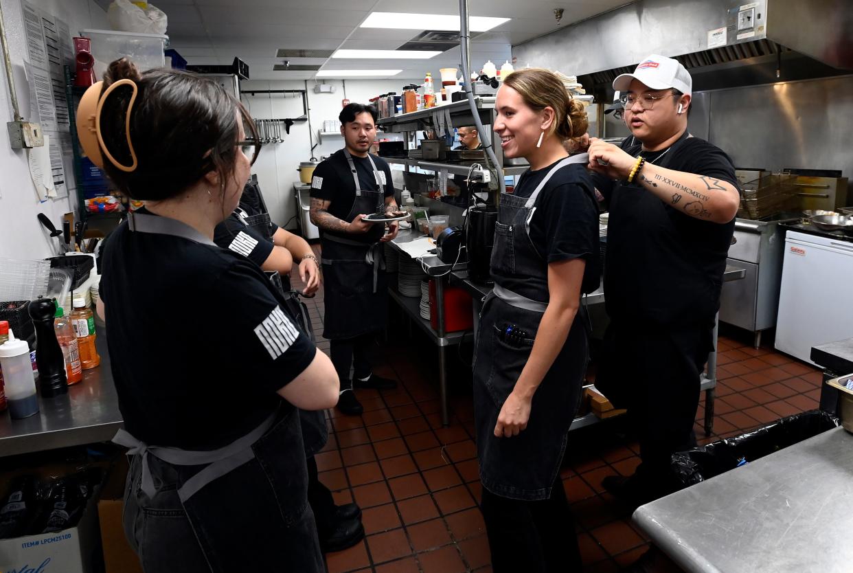 Noko executive chef Junior Vo, right, chats with staff while helping Kylie Herman with her apron Wednesday, April 17, 2024, in Nashville, Tenn.