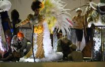 A firefighter (L) assists a reveller of the Unidos da Tijuca samba school at the Sambadrome in Rio de Janeiro, early on February 28, 2017, after the third floor of an allegorical car collapsed during the second night of Rio Carnival