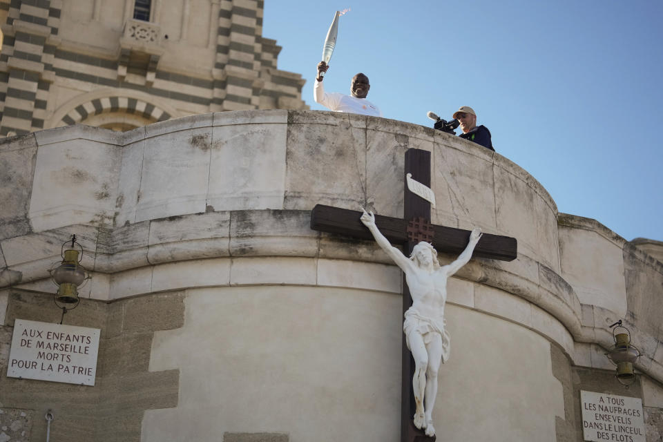 El portador de la antorcha Basile Boli participa en la primera etapa del relevo de la antorcha olímpica en Francia, en Marsella, el jueves 9 de mayo de 2024. (AP Foto/Thibault Camus)