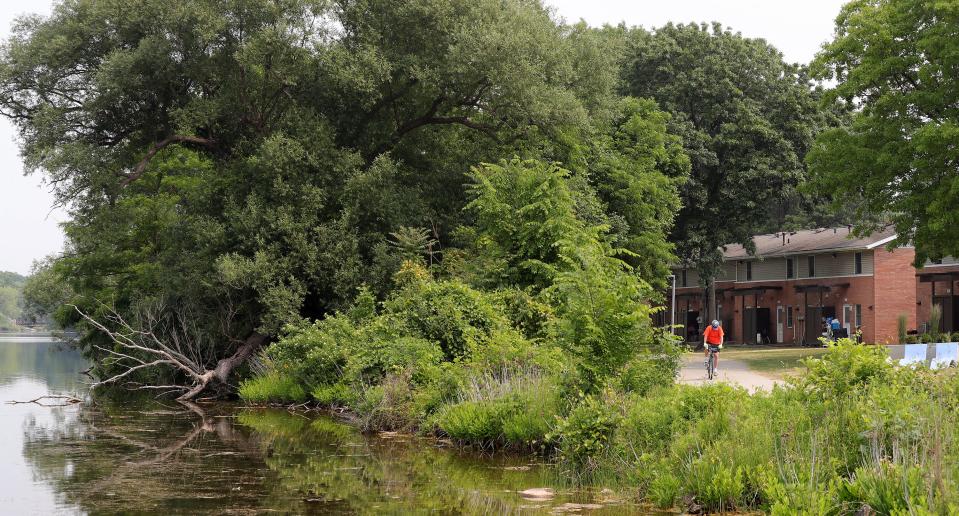 A cyclist rides on the trail past the Summit Lake Apartments in Akron.