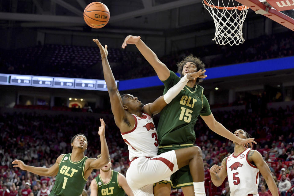 Arkansas forward Trey Wade (3) has his shot blocked by Charlotte defenders Aly Khalifa (15) and Jahmir Young (1) during the first half of an NCAA college basketball game Tuesday, Dec. 7, 2021, in Fayetteville, Ark. (AP Photo/Michael Woods)