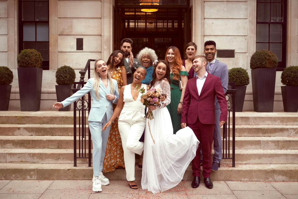A lesbian couple who have just been married leave the service with their friends and have a group photo taken