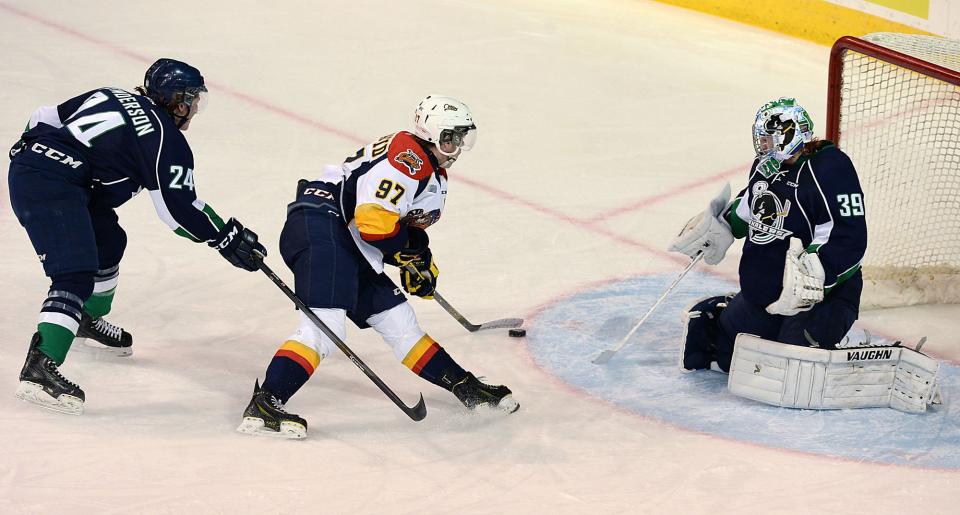 Connor McDavid (97) of the Erie Otters, gets past Plymouth Whalers&#39; Mathieu Henderson to score on goalie Alex Nedeljkovic in the first period of the Ontario Hockey League game at Erie Insurance Arena, in Erie, Pa., on Thursday, Oct. 30, 2014. (AP Photo/Erie Times-News, Jack Hanrahan)