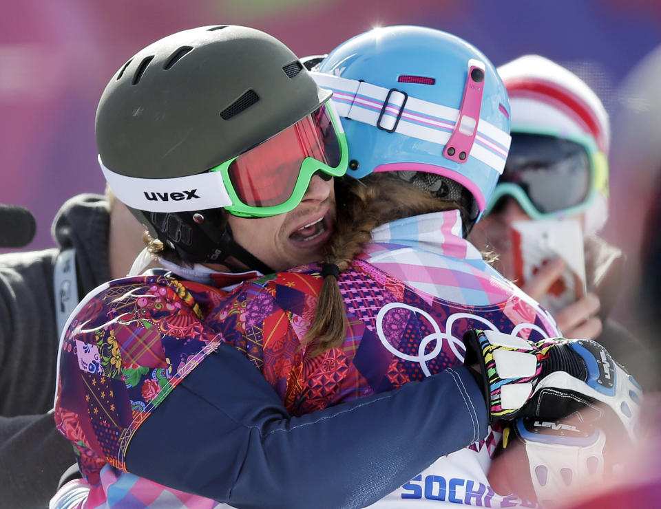 Russia's Vic Wild, left, celebrates after winning the gold medal in the men's snowboard parallel giant slalom final, with his wife and bronze medalist in the women's snowboard parallel giant slalom final, Russia's Alena Zavarzina, at the Rosa Khutor Extreme Park, at the 2014 Winter Olympics, Wednesday, Feb. 19, 2014, in Krasnaya Polyana, Russia. (AP Photo/Andy Wong)