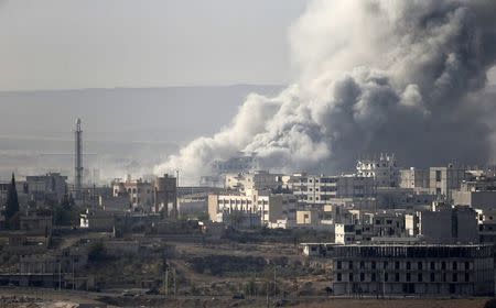 Smoke rises from the Syrian town of Kobani, seen from near the Mursitpinar border crossing on the Turkish-Syrian border in the southeastern town of Suruc in Sanliurfa province October 14, 2014. REUTERS/Umit Bektas