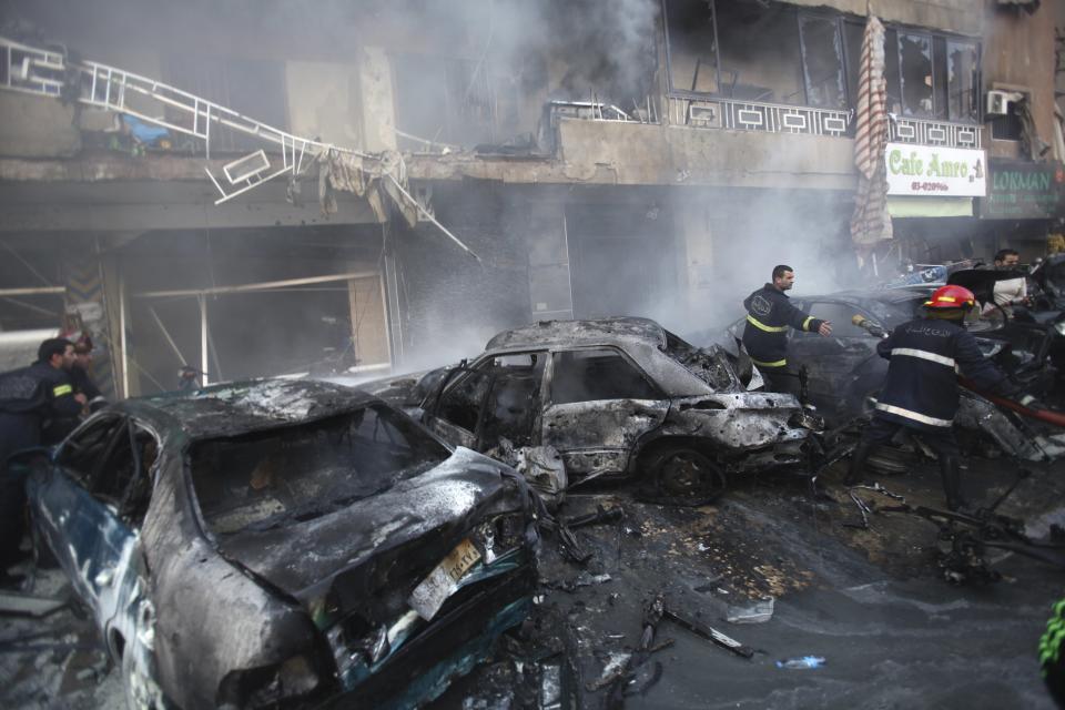 Civil defence members extinguish a fire at the site of an explosion in the Haret Hreik area, in the southern suburbs of the Lebanese capital Beirut