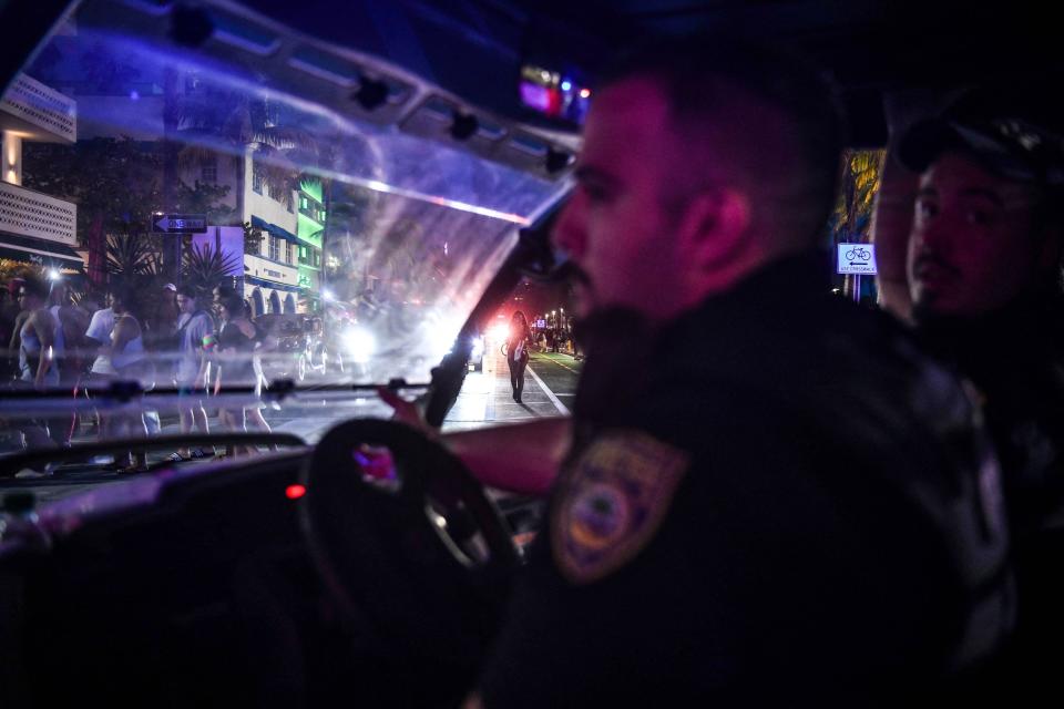 Miami Beach Police escort revelers as they gather on Ocean Drive in Miami Beach on March 15.