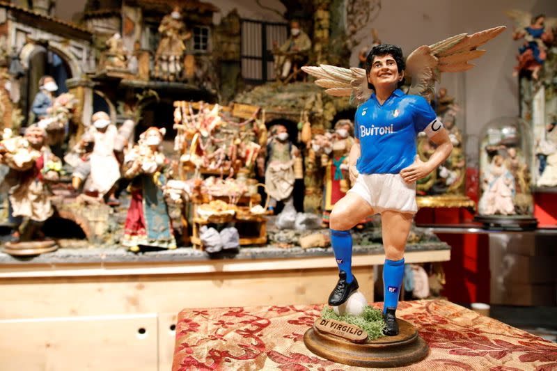 Una figura que representa a la leyenda del fútbol Diego Maradona con alas de ángel es fotografiada un día después de su muerte en un negocio en Via San Gregorio Armeno