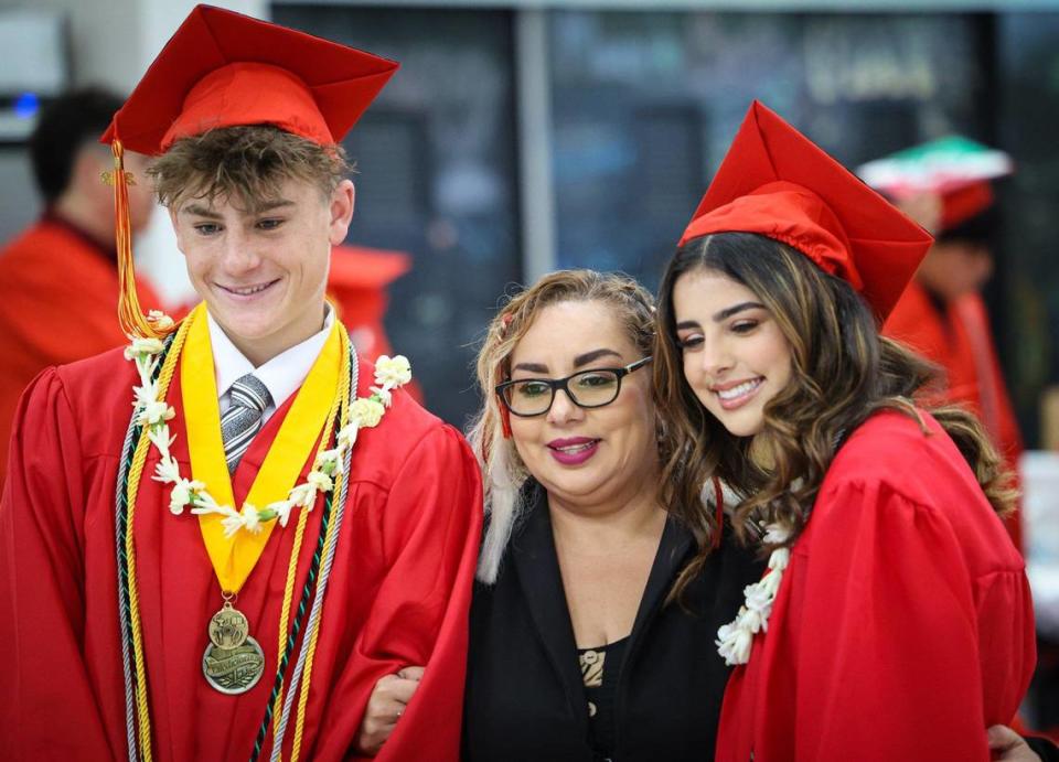 Coast Union High School graduates Caiden Kennedy and Patty Acosta pose with Lupe Aguilar, the school registrar, before a commencement ceremony for the Class of 2023 in Cambria on June 1, 2023.